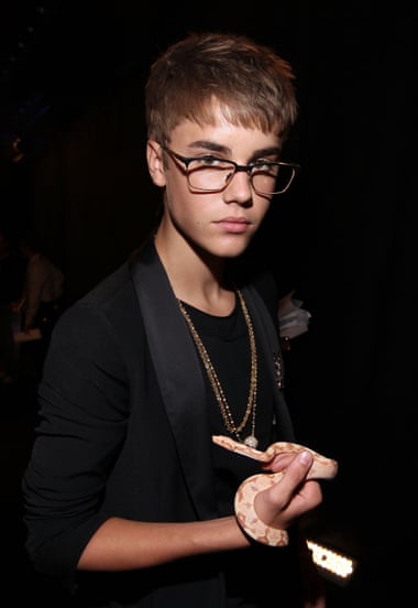 Justin Bieber wearing glasses and, for some reason, holding a snake.