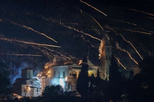 Fireworks rockets fly over a church