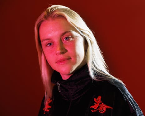 Alessia Russo, in an Arsenal jacket, poses for a portrait under red lighting