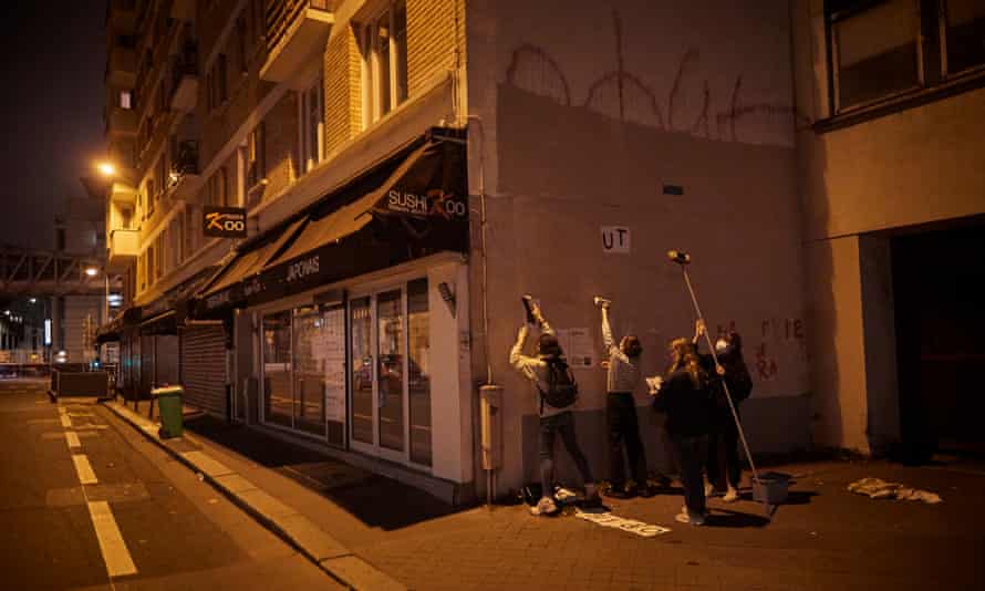 Activists known as Les Colleuses paste anti-femicide posters on a wall in Paris in October last year.