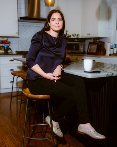 She sits on a bar stool at a marble-topped island