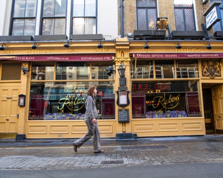 A woman in a grey suit walks past Rules