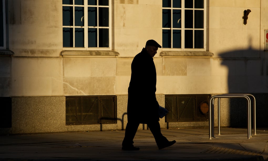 The silhouette of an older man walking along the street in Manchester
