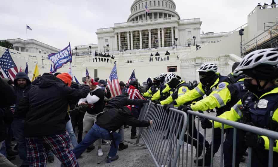 Trump supporters try to break through a police barrier at the Capitol in Washington DC on 6 January.