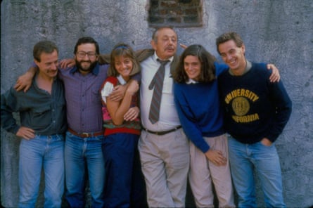 a group of people pose for a photo in front of a wall