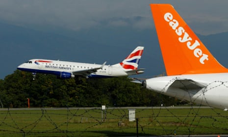 A British Airways aircraft lands next to a EasyJet plane ready for take off at Cointrin airport in Geneva