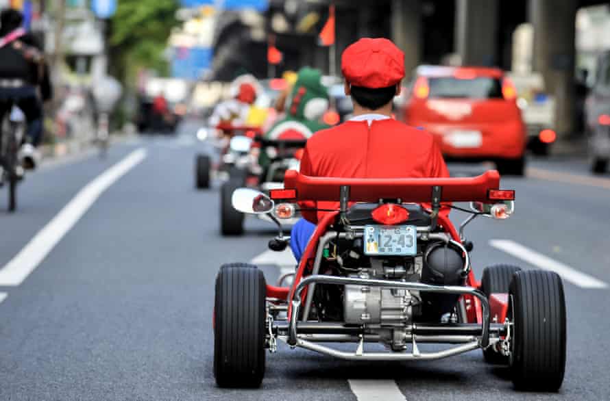 Super Mario character driving around Tokyo on go karts.