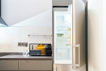 Open refrigerator next to a bench with microwave