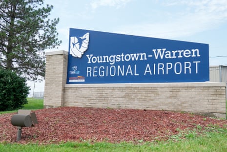 A blue sign for the Youngstown-Warren Regional Airport, surrounded by grass and mulch