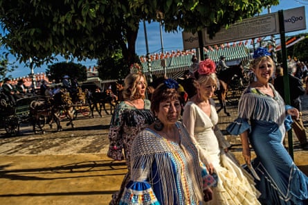Women wearing traditional Sevillana dresses soak up the atmosphere at the Feria de Abril in Seville, Spain. The April fair, which dates to 1857, takes place annually a fortnight after Easter