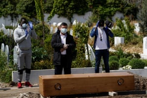 Mourners pray in front of the coffin of a person who died from coronavirus, at the Spanish Muslim military cemetery in Grinon.
