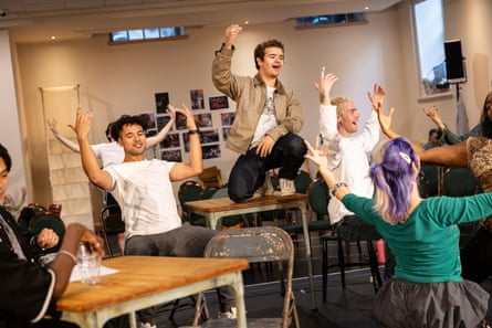 Actors in a rehearsal room throwing their hands in the air