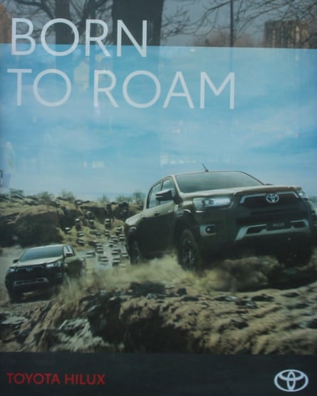 A poster showing two Toyota Hilux SUVs followed by a swarm of others.