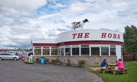 An exterior view of the 1960s roadside cafe with a lifesize cow on the roof.