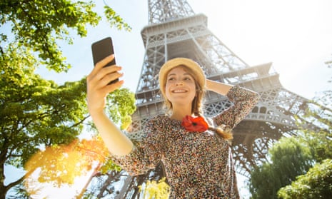 Woman taking selfie in front of Eiffel Tower