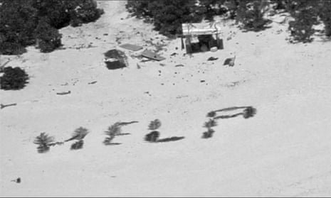 a close-up of help spelled out in leaves on a sandy beach