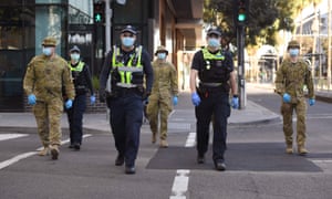 A group of police and soldiers patrol the Docklands area of Melbourne on August 2, 2020, after the announcement of new restrictions to curb the spread of the COVID-19 coronavirus. - Australia on August 2 introduced swe