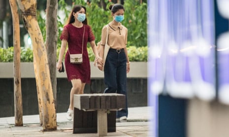 two women in masks walking in singapore