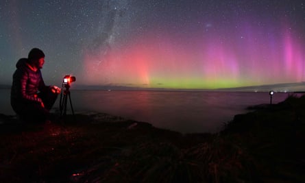 Seorang fotografer memotret Aurora Australis di atas Danau Ellesmere di pinggiran Christchurch, Selandia Baru.