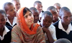 Malala Yousafzai looking thoughtful with a group of boys in school uniform