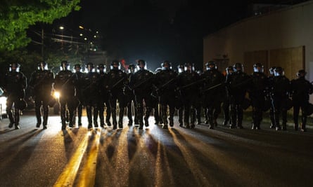 Die Polizeibeamten von Portland gehen durch das Viertel Laurelhurst, nachdem sie am frühen Samstag einen Protest von etwa 200 Personen vor dem Büro des Sheriffs des Landkreises Multnomah verteilt haben.
