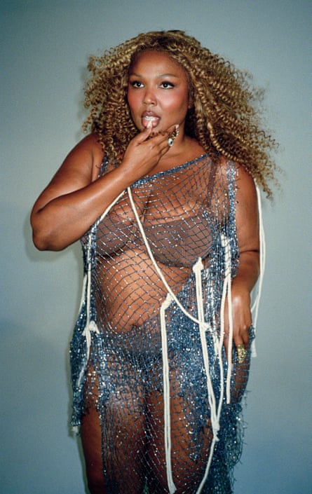 Lizzo wearing brown underwear and a silvery-blue mess dress