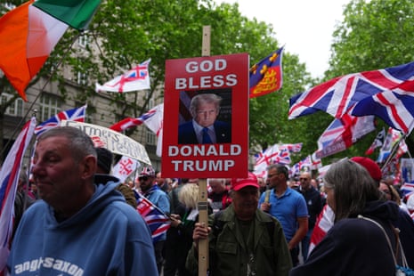 A man holds up a placard with the words 'God Bless Donald Trump' as people take part in a Unite The Kingdom protest.