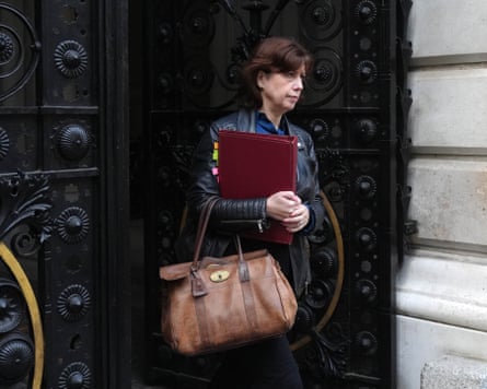 Lucy Powell arrives at Downing Street and walks through large, ornate black doors. She holds a large brown handbag and a red folder of documents.