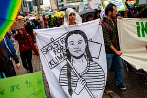 A woman holds a banner with a drawing of Greta Thunberg during a protest for climate action in Istanbul, Turkey.