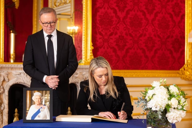 Anthony Albanese and his partner Jodie Haydon sign a book of condolence at Lancaster House in London on Saturday.