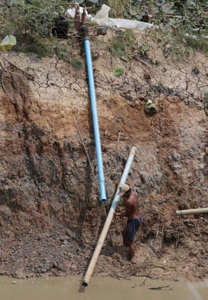 A Cambodian farmer prepares a pipe to pump water from an almost dried-up lake in Kandal province, Cambodia.