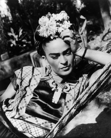 Frida Kahlo circa 1950 wearing a folk costume and flowers in her hair.