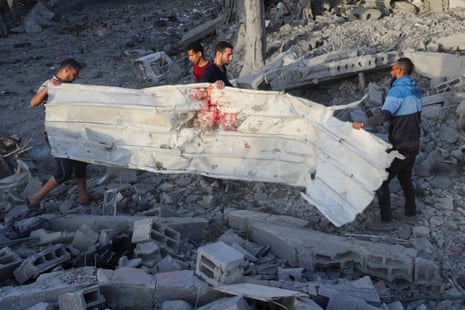 Palestinians inspect the site of an Israeli strike on a house in Jabalia, in the northern Gaza Strip, 14 May.