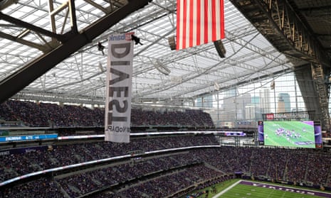 Two protesters hang suspended from ropes above the Minnesota Vikings and Chicago Bears football game.