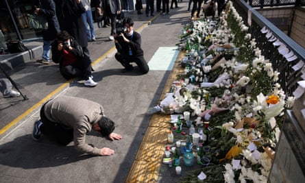 A man makes a deep bow while paying tribute near the site of a crush that happened during Halloween festivities in Seoul