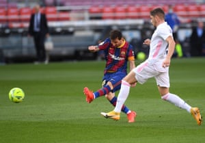Lionel Messi of Barcelona shoots past Federico Valverde of Real Madrid.