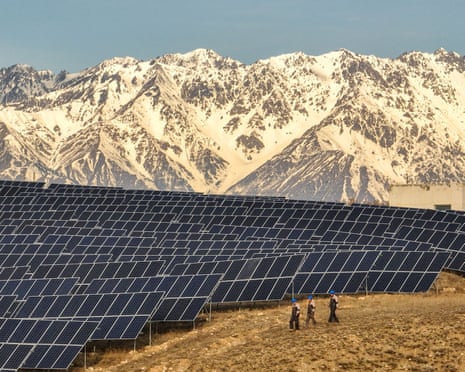 Workers of Huaneng Yili Xexin Photovoltaic Power Plant inspect equipment on a barren slope in Yili, Xinjiang province, China, on 30 November, 2024.