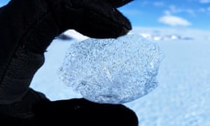 a gloved hand holding a ball of ice