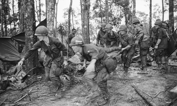 A quartet of U.S. 101st Air Division troopers keep low as they rush a stretcher-borne wounded comrade to a medical aid station during the battle for Hamburger Hill. 