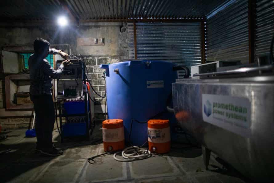 Kishore Chemte, 25, installs a Promethean Power Systems 1,000-litre milk collection unit in Tungi, Latur District, Maharashtra