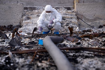 Hironaka crouches in the charred debris