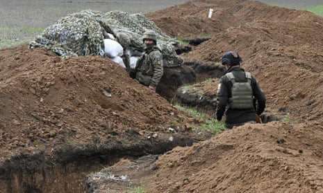 Ukrainian service personnel stand in trenches near the town of Bakhmut, in the Donetsk region