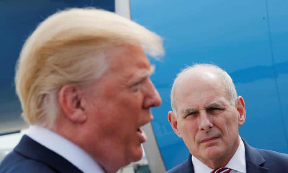 John Kelly listens as Donald Trump talks to the media beside Air Force One.