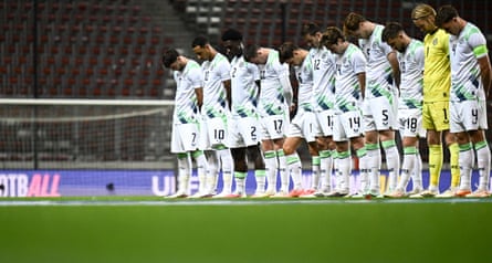 The Republic of Ireland team line up on the pitch with their heads bowed