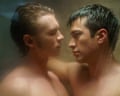Two men gaze at each other romantically in the shower