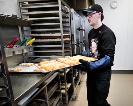A Greggs worker carrying a large tray of goods