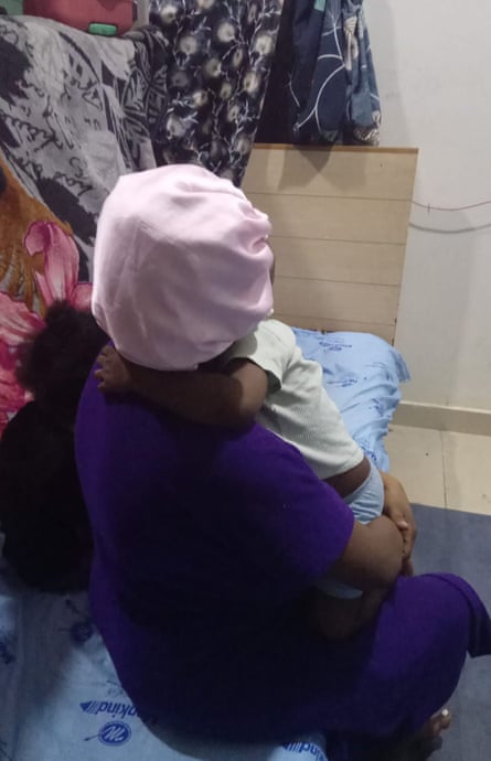 A woman looking away from the camera holds a small boy