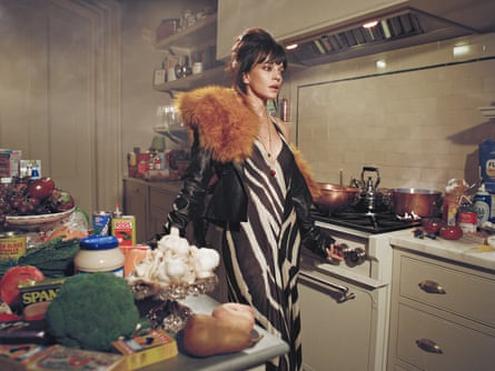 Woman wears glamorous clothing in messy kitchen