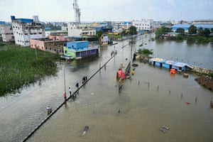 Chennai, India Commuters wade across a flooded street after heavy rains