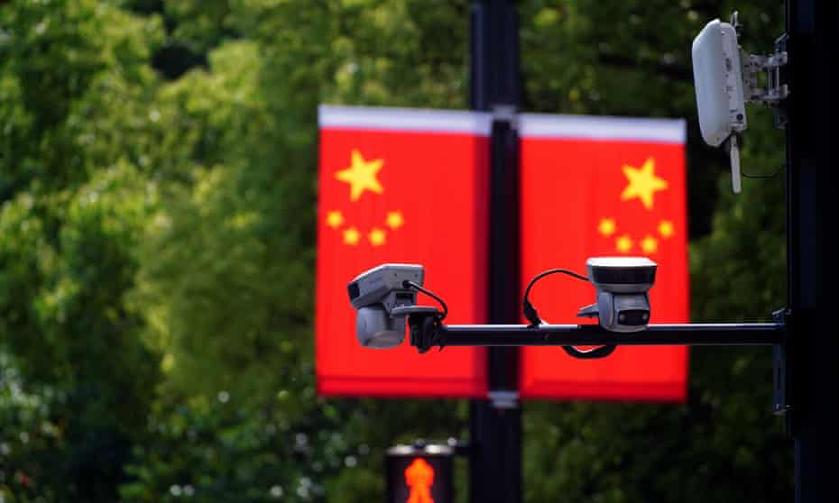 Surveillance cameras are seen in front of Chinese flags at a shopping area in Shanghai in May. 